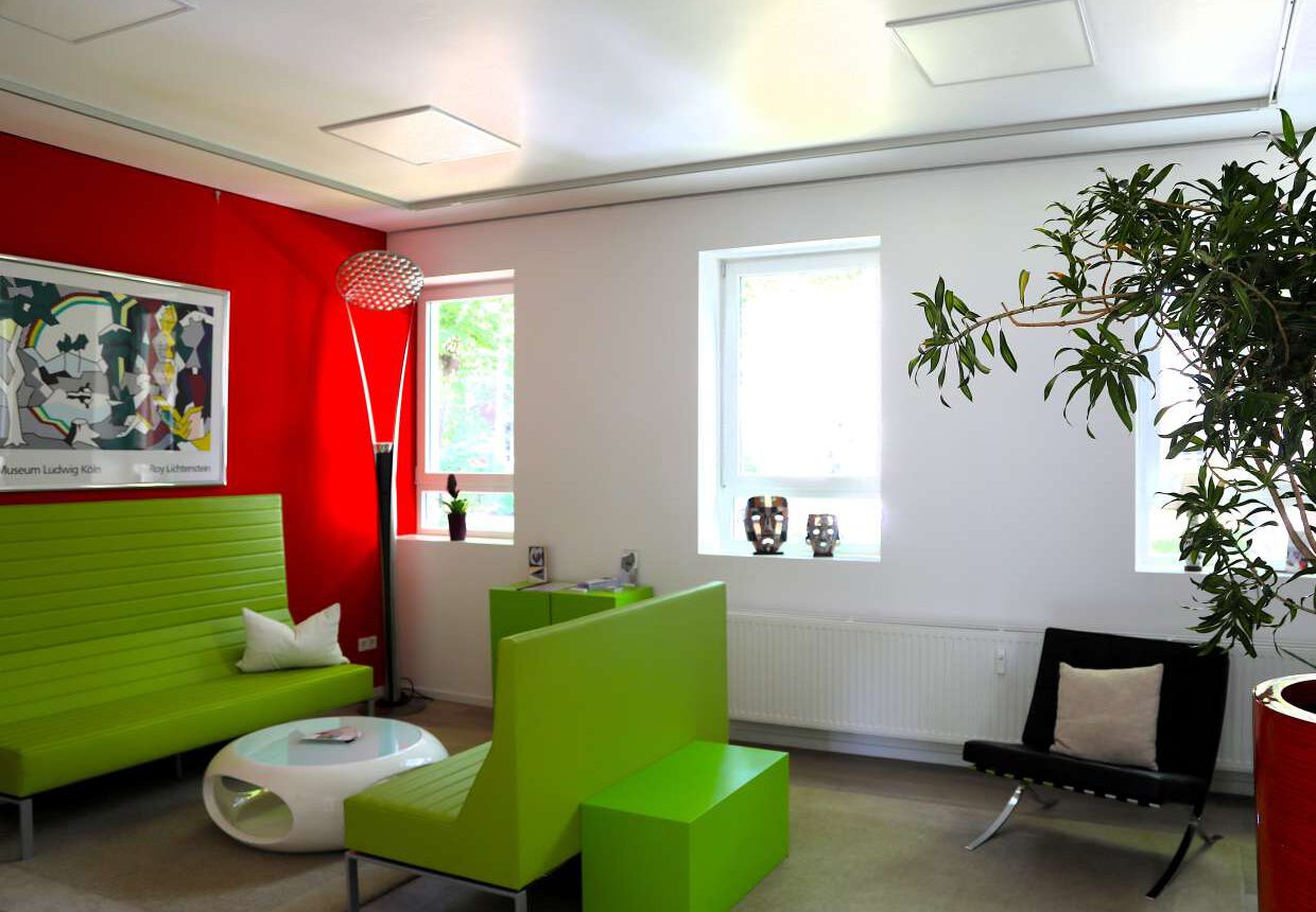 Patientenlounge mit Sesseln und Tisch